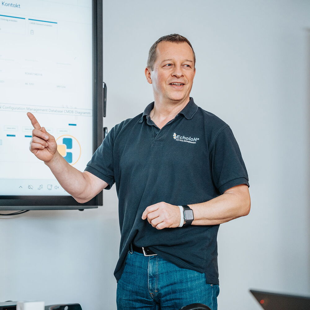 Mitarbeiter von mIT solutions präsentiert die EcholoN Software vor einem Bildschirm und erklärt digitale Prozesse und Funktionen im Meeting
