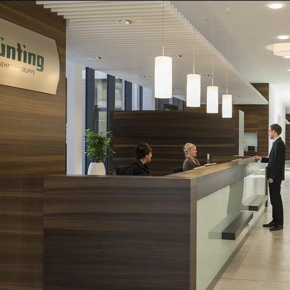 Empfangsbereich der Bünting Unternehmensgruppe mit Rezeption und Mitarbeiter im Gespräch als Symbol für professionellen Kundenservice und zentrale Anlaufstelle